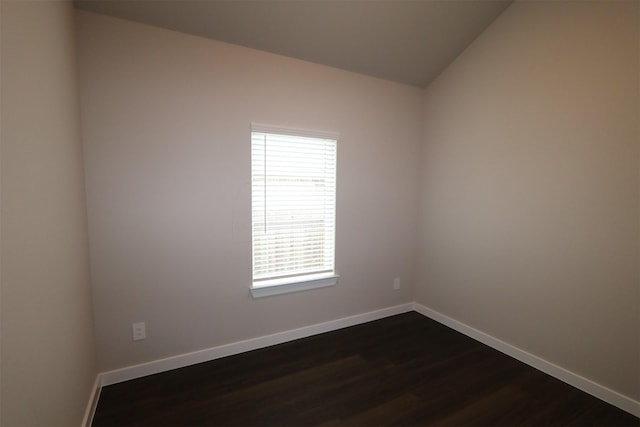 unfurnished room featuring vaulted ceiling and dark hardwood / wood-style flooring