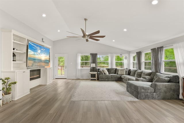 living room with ceiling fan, light wood-type flooring, and lofted ceiling