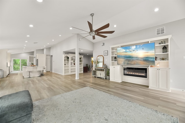 unfurnished living room with ceiling fan, light hardwood / wood-style floors, and vaulted ceiling