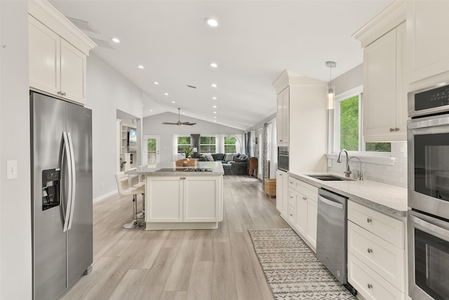 kitchen featuring stainless steel appliances, plenty of natural light, hanging light fixtures, and sink