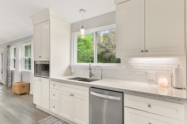 kitchen with light wood-type flooring, stainless steel appliances, white cabinets, sink, and decorative light fixtures