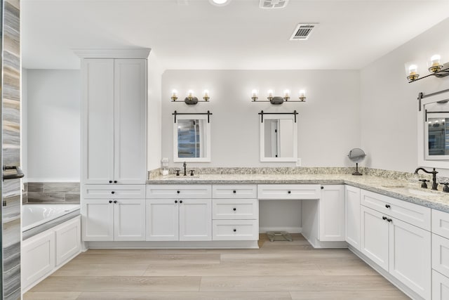 bathroom featuring a tub, vanity, and hardwood / wood-style flooring