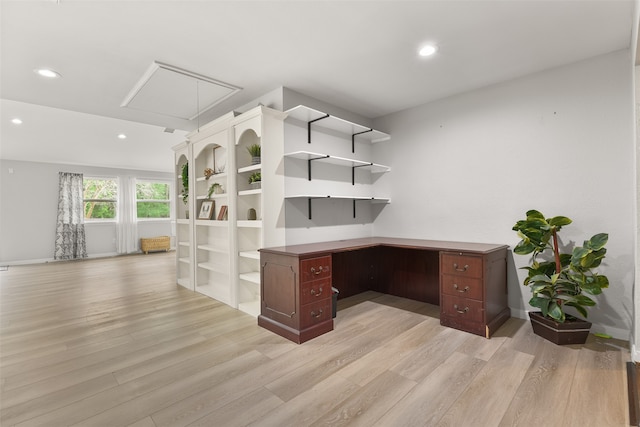 unfurnished office featuring light hardwood / wood-style flooring and built in desk