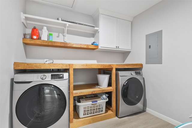 laundry room with cabinets, electric panel, light hardwood / wood-style flooring, and washer / dryer