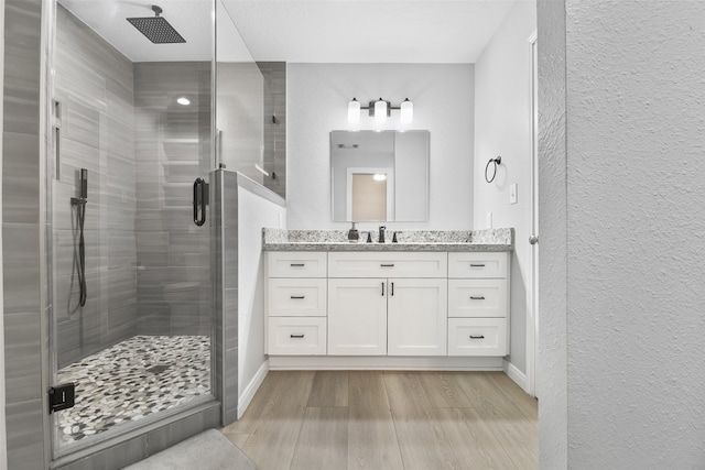 bathroom with vanity, a shower with door, and hardwood / wood-style flooring