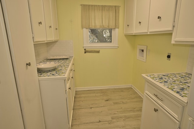 laundry room featuring washer hookup, sink, light hardwood / wood-style floors, and hookup for an electric dryer