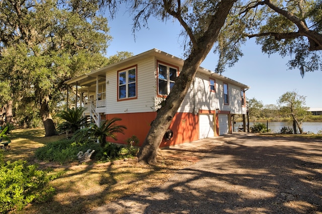 view of front of property featuring a garage and a water view