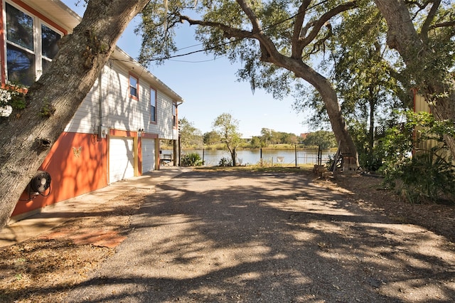 view of yard with a garage and a water view