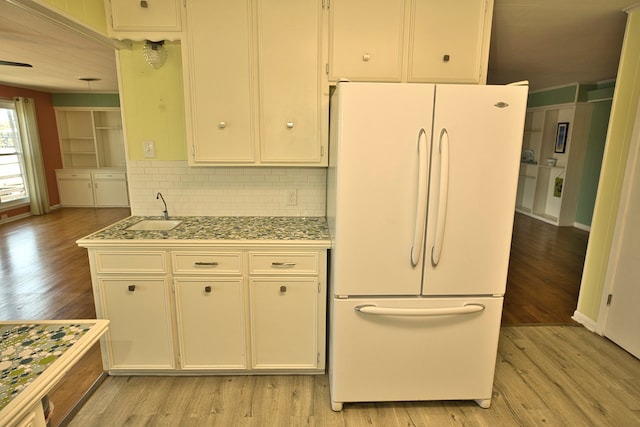 kitchen featuring white cabinetry, light hardwood / wood-style flooring, sink, and white fridge