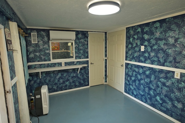 interior space featuring a textured ceiling and a wall mounted air conditioner