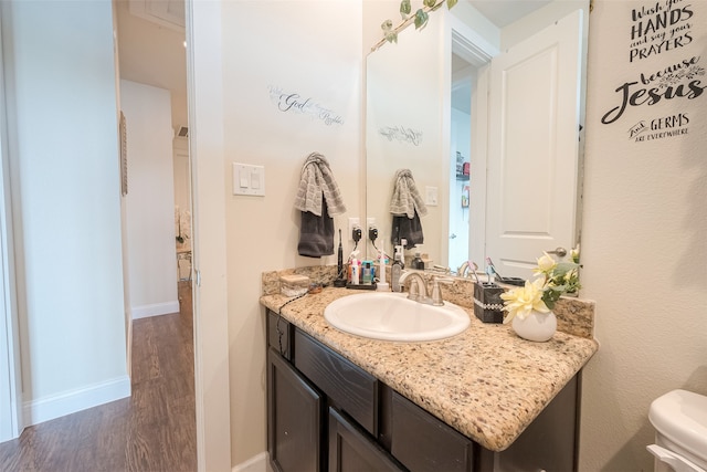 bathroom featuring toilet, vanity, and hardwood / wood-style flooring