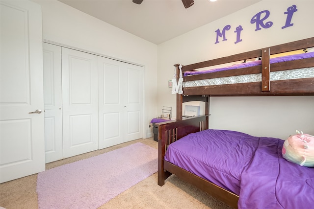 carpeted bedroom with ceiling fan and a closet