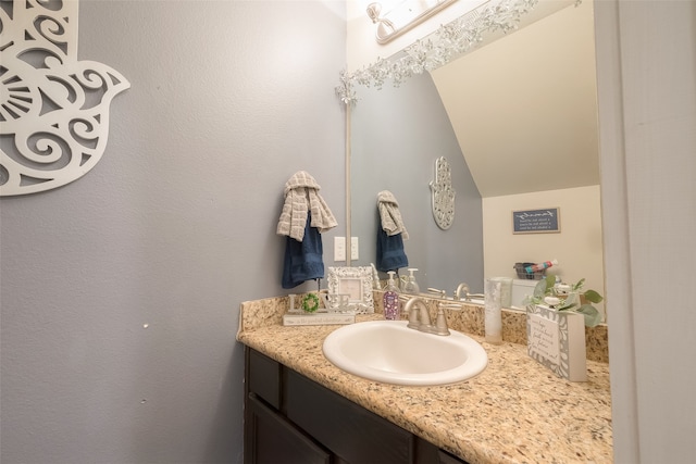 bathroom with vanity and vaulted ceiling