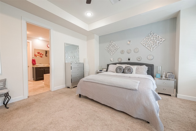 bedroom featuring light carpet, ceiling fan, and connected bathroom