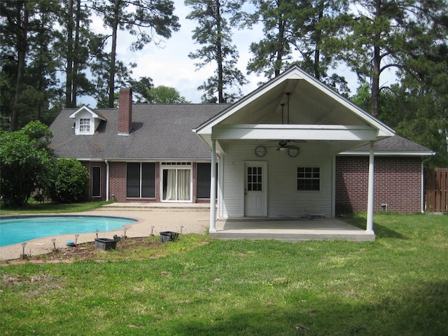 back of house featuring ceiling fan, a patio, and a lawn