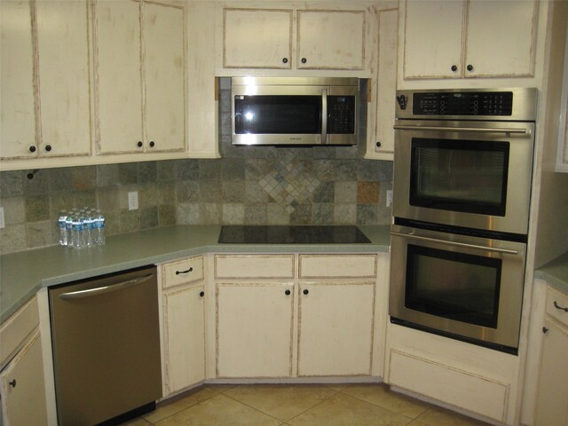 kitchen featuring backsplash, stainless steel appliances, and light tile floors