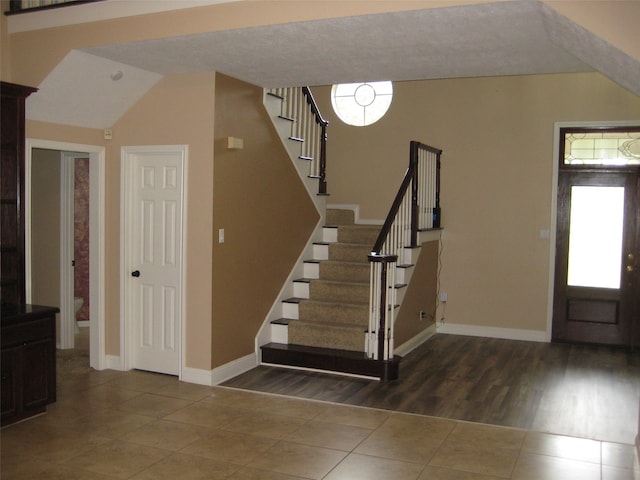 tiled foyer featuring lofted ceiling