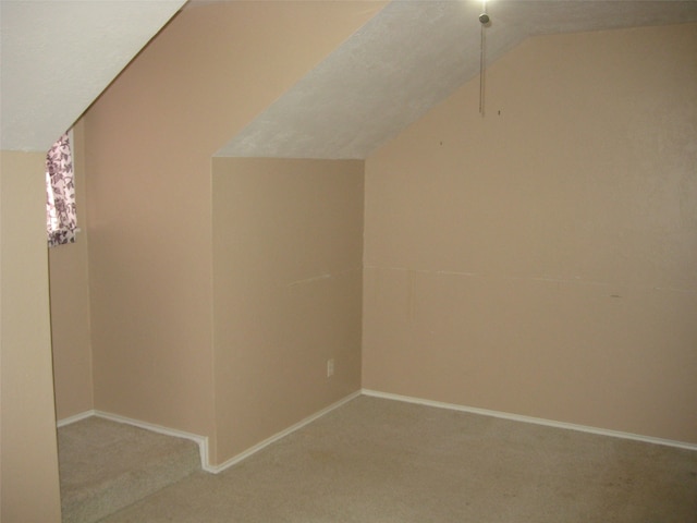 interior space featuring light colored carpet and vaulted ceiling