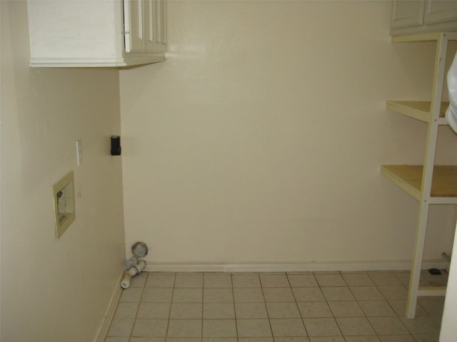 laundry area with cabinets and light tile flooring