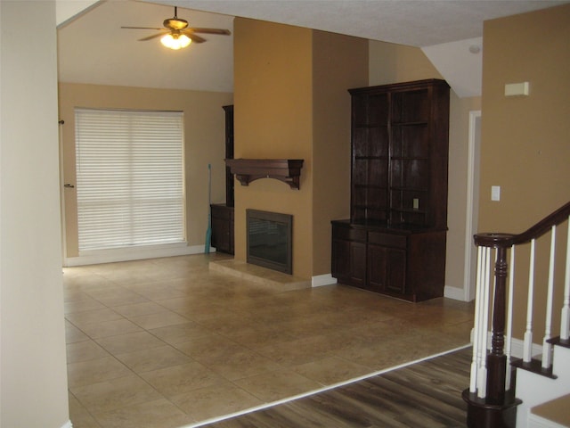 unfurnished living room featuring ceiling fan and light tile floors