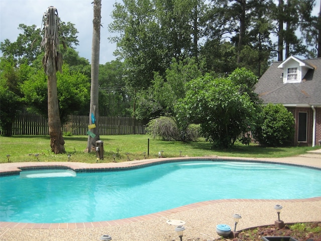 view of swimming pool featuring a yard