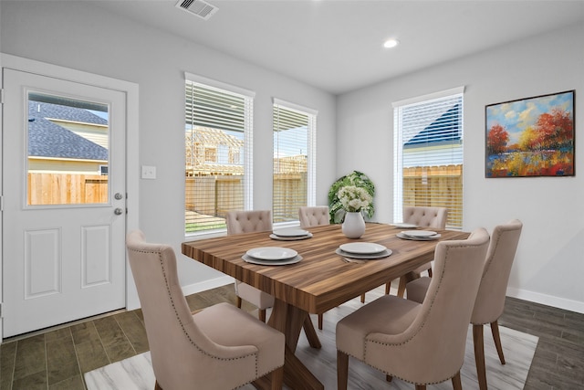 dining area with a wealth of natural light and dark wood-type flooring