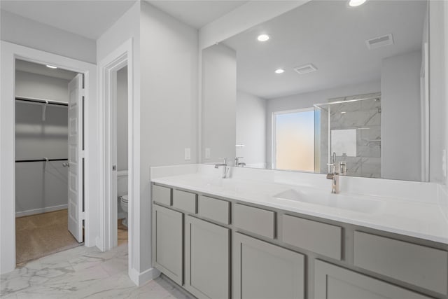 bathroom featuring walk in shower, vanity, and toilet