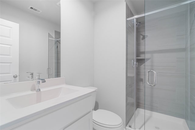 bathroom featuring vanity, toilet, and a shower with shower door