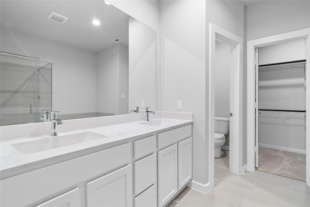 bathroom featuring vanity, toilet, and an enclosed shower