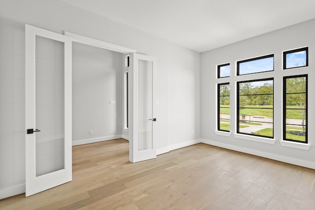 unfurnished bedroom with light wood-type flooring and french doors