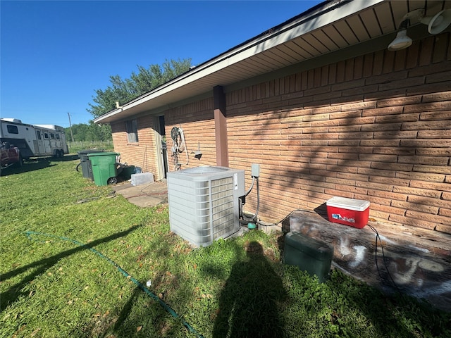 view of property exterior featuring central AC unit and a yard