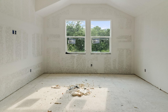 unfurnished room featuring vaulted ceiling