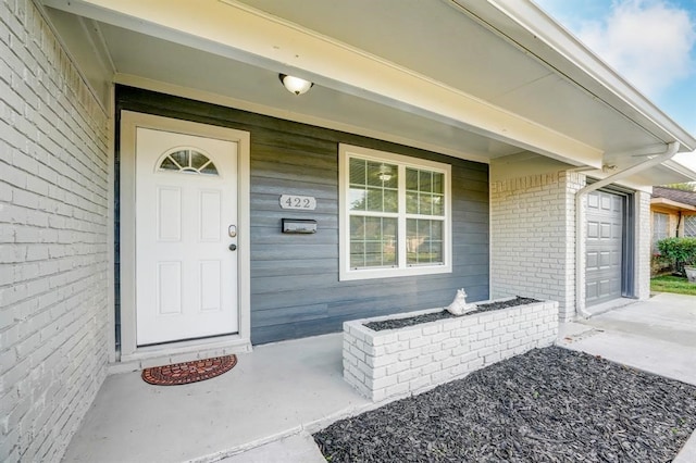 doorway to property with a garage and a porch