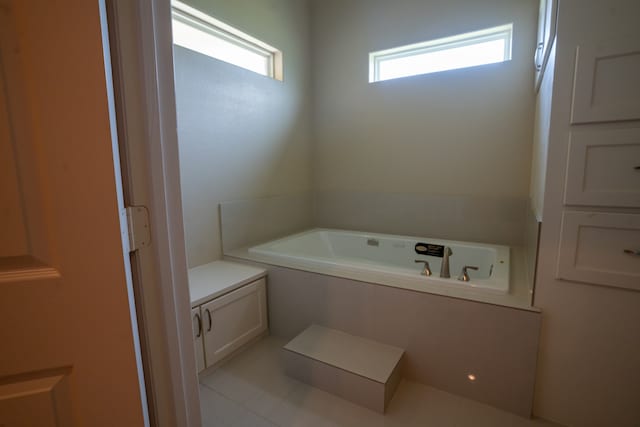 bathroom with a tub and tile floors