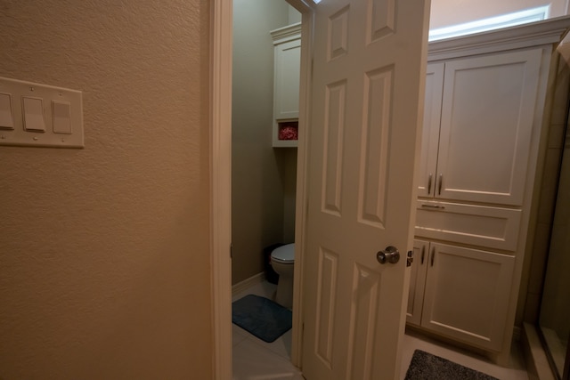 bathroom with tile flooring and toilet