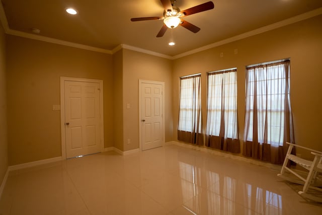 tiled spare room with ornamental molding, a healthy amount of sunlight, and ceiling fan