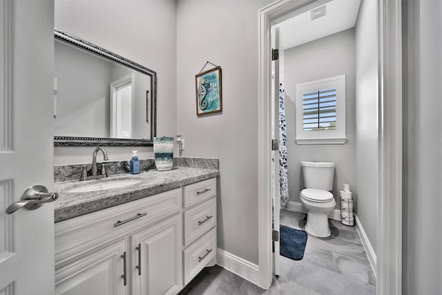 bathroom featuring large vanity, toilet, and tile flooring