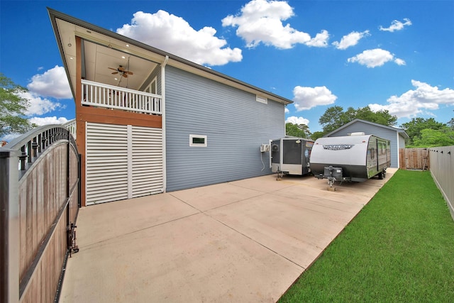 rear view of house with a patio, a yard, and ceiling fan