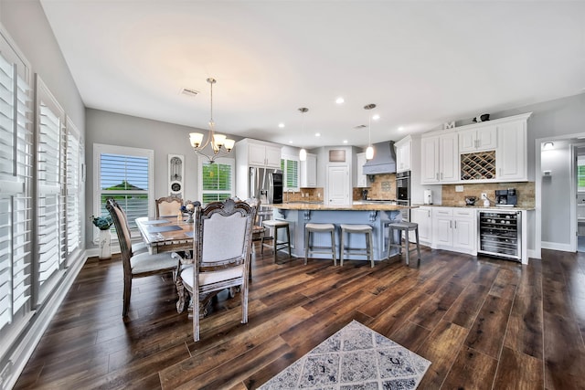 dining room with wine cooler, dark hardwood / wood-style floors, and a notable chandelier