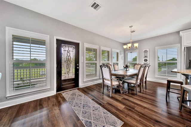 dining area with dark hardwood / wood-style flooring and a chandelier