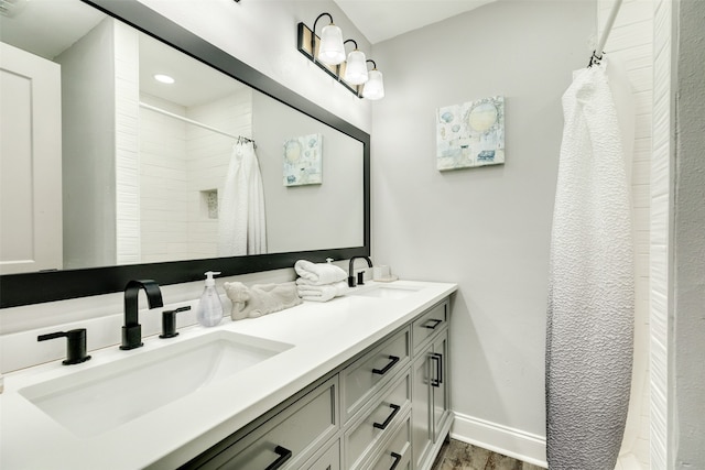 bathroom featuring dual sinks, vanity with extensive cabinet space, and hardwood / wood-style flooring