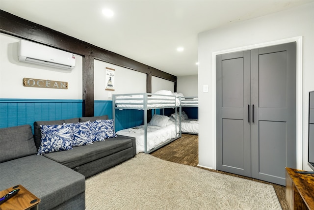 bedroom with a wall mounted AC and dark wood-type flooring