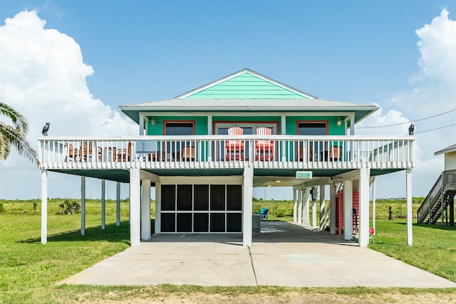 raised beach house with a carport, a porch, and a front lawn