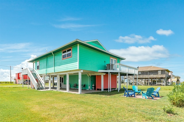 rear view of property featuring a deck, a yard, and a patio area