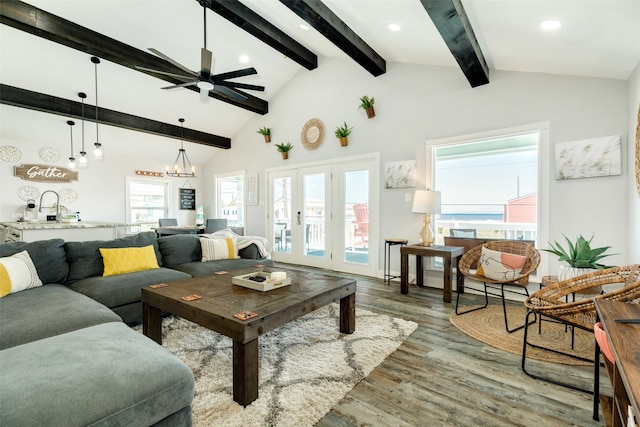 living room with ceiling fan with notable chandelier, vaulted ceiling, french doors, and dark wood-type flooring