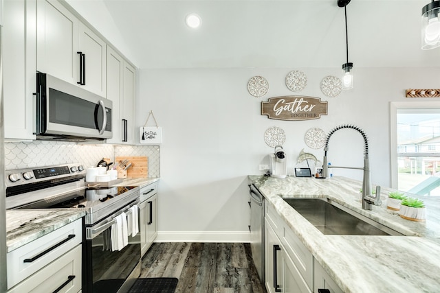 kitchen featuring decorative light fixtures, appliances with stainless steel finishes, tasteful backsplash, light stone counters, and dark hardwood / wood-style flooring