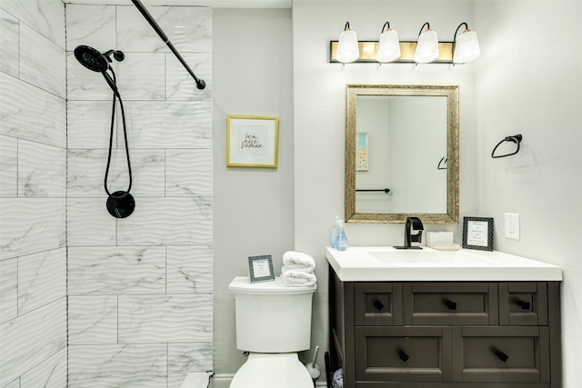 bathroom with toilet, vanity, and a tile shower