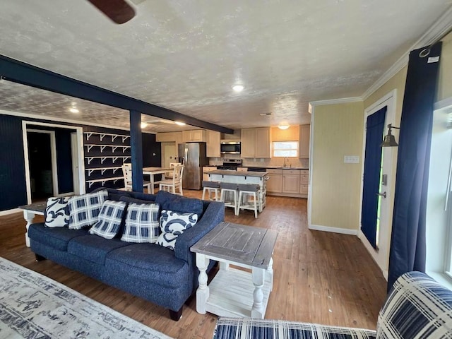 living room featuring ceiling fan, an AC wall unit, crown molding, and hardwood / wood-style flooring