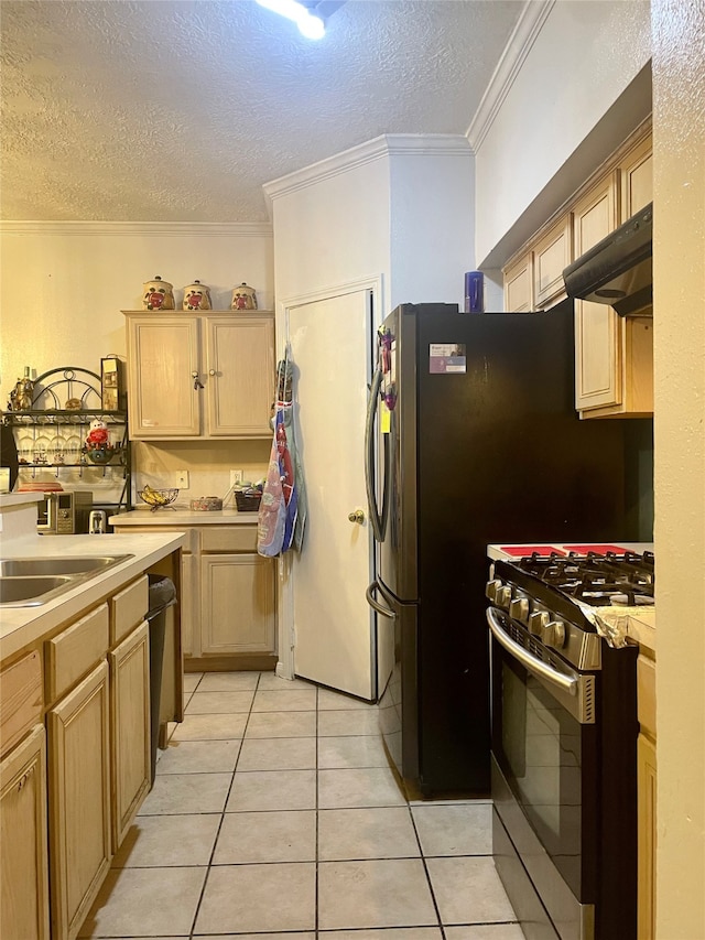 kitchen featuring stainless steel gas stove, a textured ceiling, light tile patterned floors, and light brown cabinetry