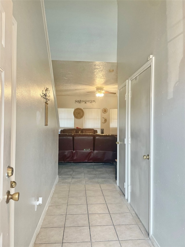 hallway featuring light tile patterned flooring and crown molding